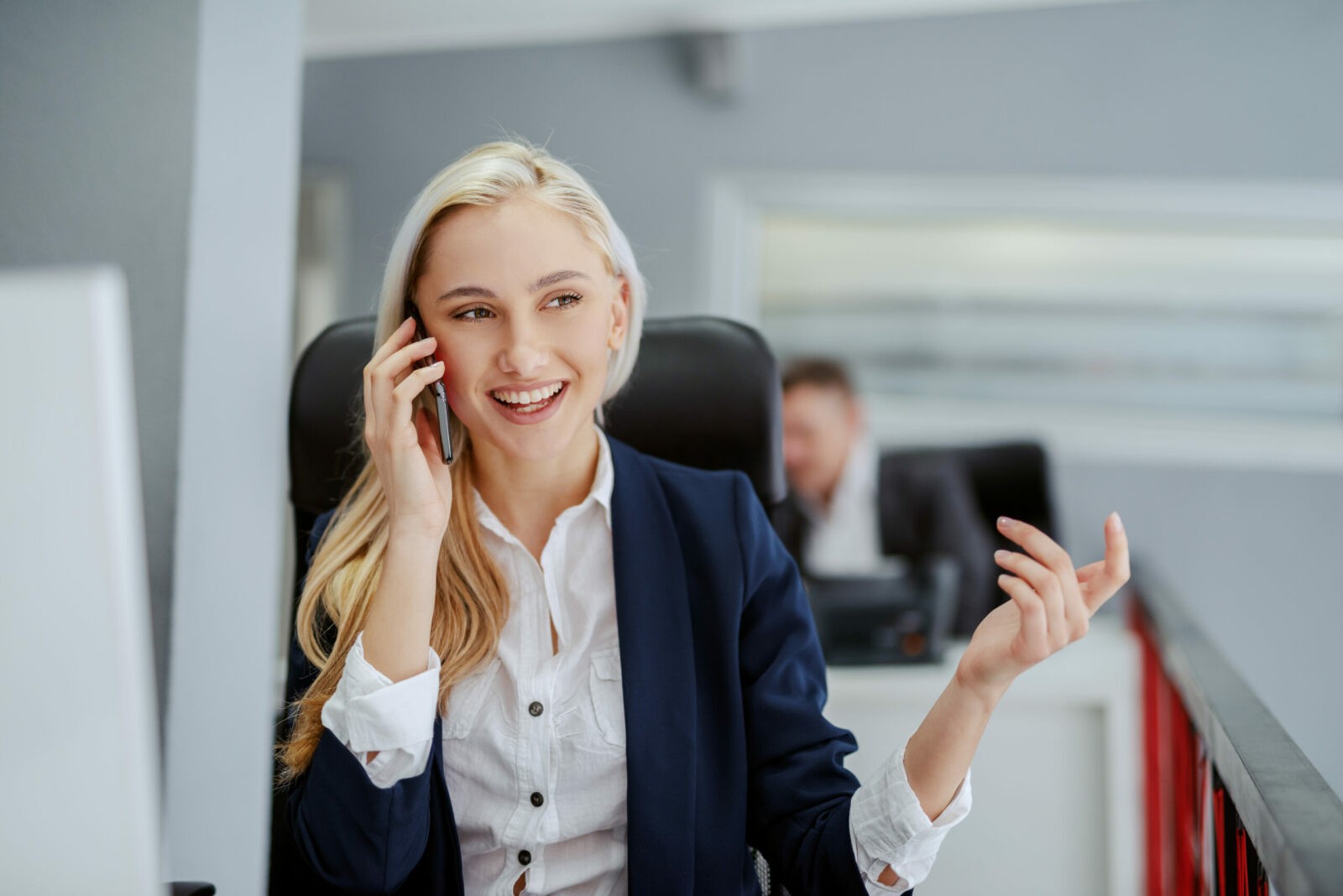 Young smiling blonde Caucasian businesswoman sitting in office and using smart phone for business talk. Without struggle there is no progress.